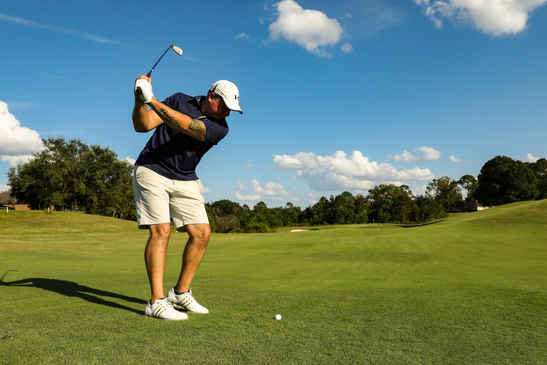Golfer mid backswing on the course